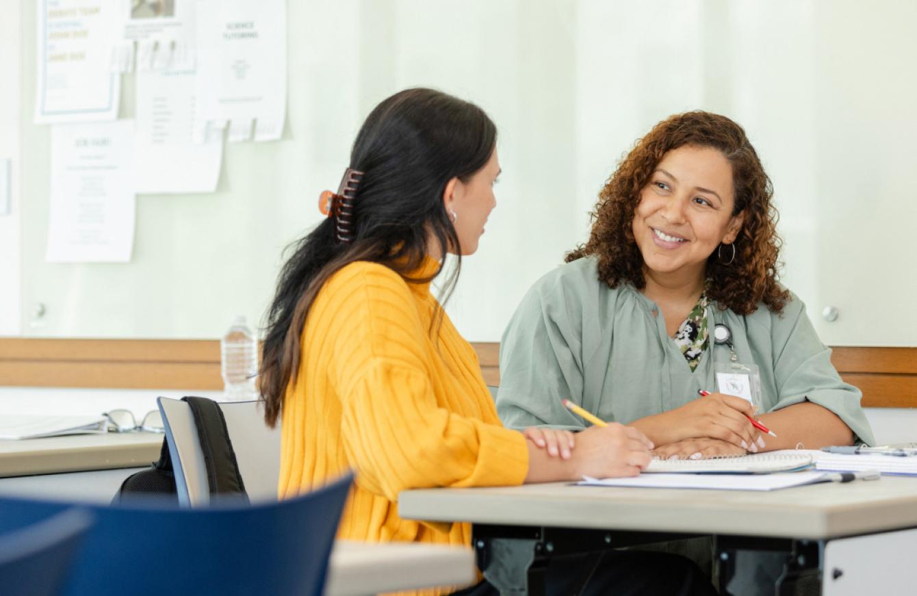 Two smiling women at a desk